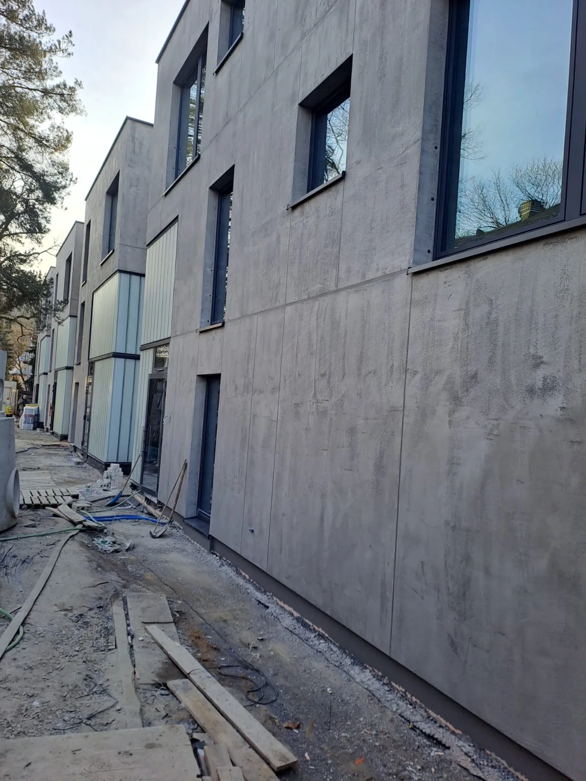 Nowoczesna elewacja budynku w procesie wykończenia z efektem betonu