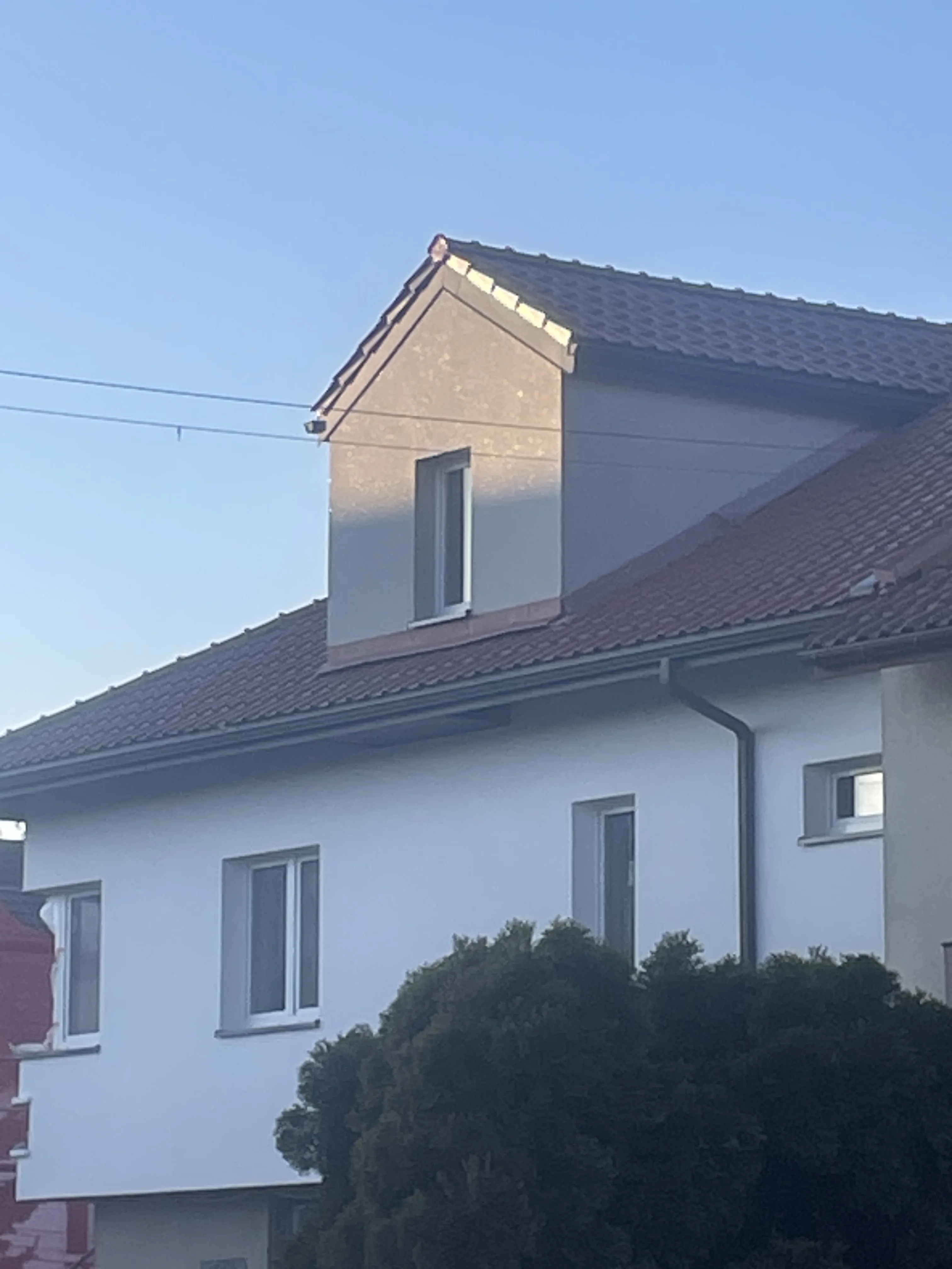 Elewacja domu z nowoczesnym tynkiem oraz odnowionym dachem