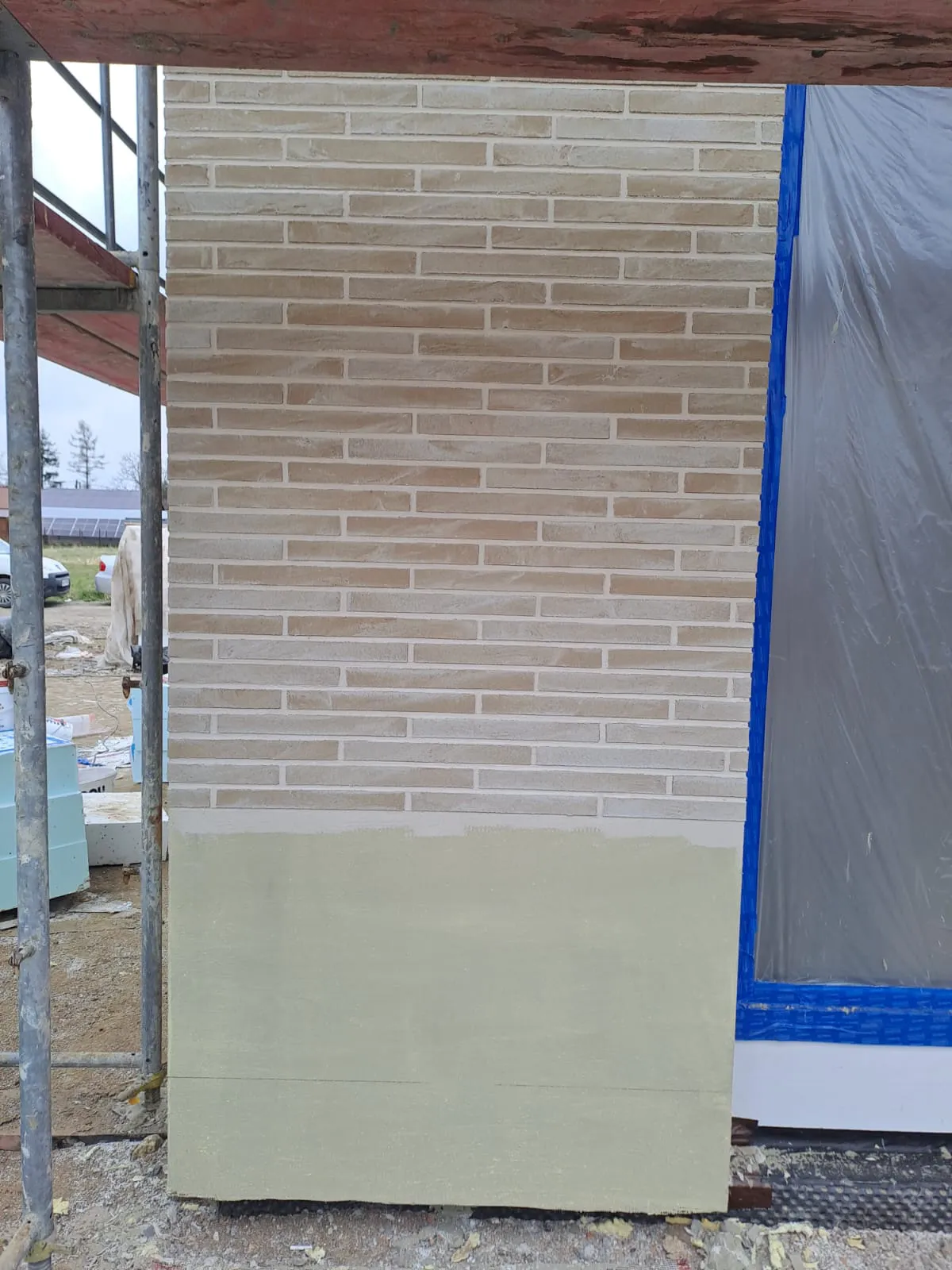 Fragment elewacji budynku z tynkiem architektonicznym i imitacją klinkieru