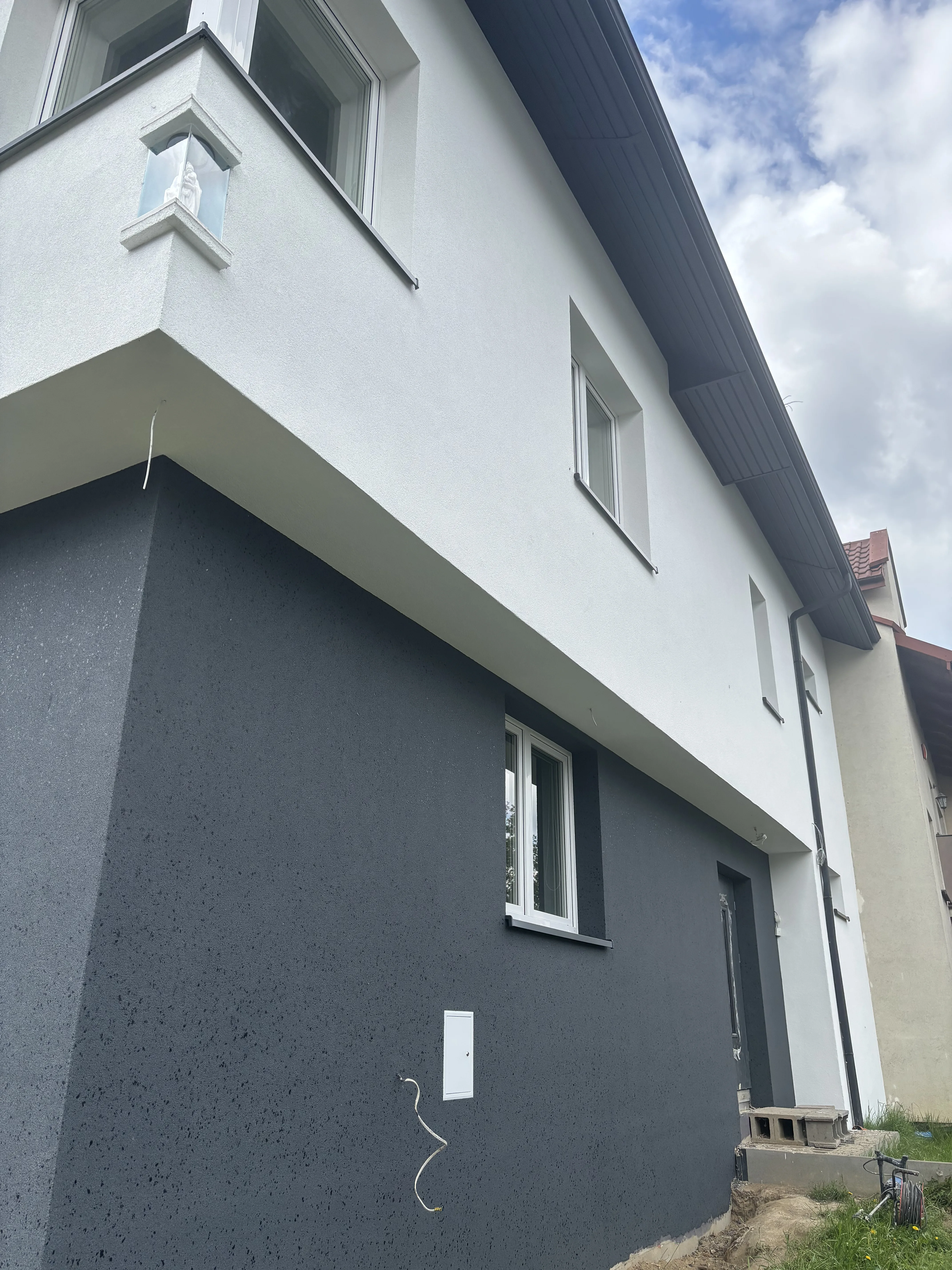 Elewacja budynku z tynkiem architektonicznym w odcieniach szaro-białych